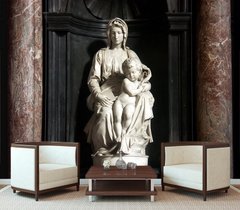 Sculptură a unei femei cu un copil între coloane