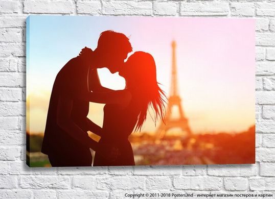 Влюбленная парочка целуется на фоне башни Эйфеля