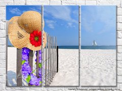 Pălărie cu floare pe gardul plajei