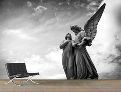 Скульптура ангела и девушки на фоне неба