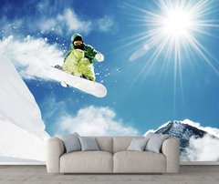 Snowboarder pe fundalul munților și al soarelui strălucitor