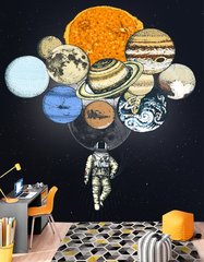 Космонавт со связкой планет вместо воздушных шаров на черном фоне