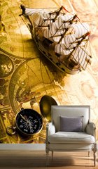 Парусный кораблик и компас на фоне старинной карты