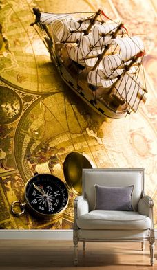 Парусный кораблик и компас на фоне старинной карты