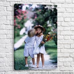 Мальчик целует девочку с букетом цветов