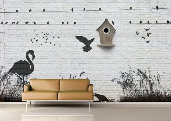 Model negru cu păsări pe un perete de cărămidă albă