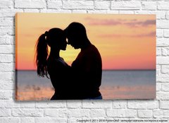 Влюбленная пара обнимается и целуется на закате