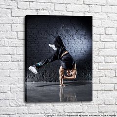 Танцор брейк данс на фоне черной кирпичной стены